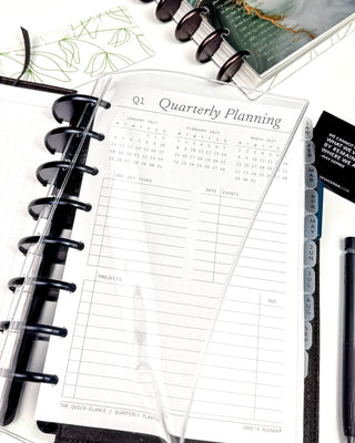 Discbound quarterly planning page in a disc planner with stationery items on a white surface