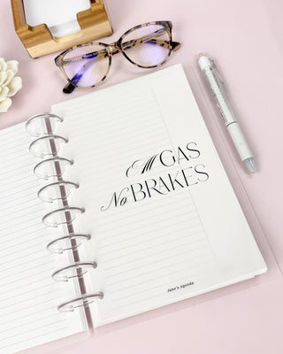 Discbound planner with a vellum paper dashboard featuring a black typography  style quote sitting on a desk surface.