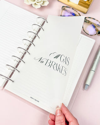 Discbound planner with a vellum paper dashboard featuring a black typography  style quote sitting on a desk surface.