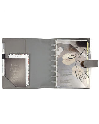 The grey planner showing a planning tucked into the back pocket, a task notepad and quote card in the front pockets and pens in each penloop. 