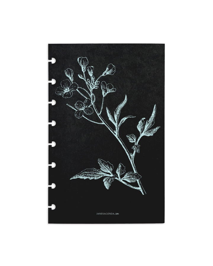 A white blossom print on black cardstock as a dashboard for discbound planners, disc notebooks, and A5 size planner binders by Jane's Agenda.
