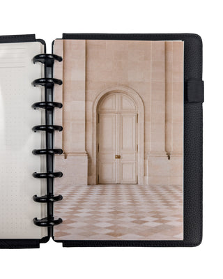 A beige stone doorway with beige checkerboard floor tiles planner dashboard, snapped into a planner with Black Plastic Discs and Black Vegan Leather Snap-on Cover on a white background. 