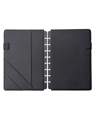 Flat lay of an open black snap on planner cover from Jane's Agenda showing interior pockets, elastic pen loops, and an embossed Jane’s Agenda logo.