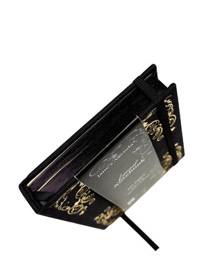 Topdown view of a black journal with gold highlights around the edges.