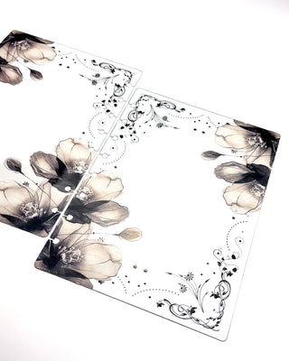 Angled view of matching front and back clear discbound planner covers featuring monochrome floral artwork, ornate botanical details, and transparent construction.