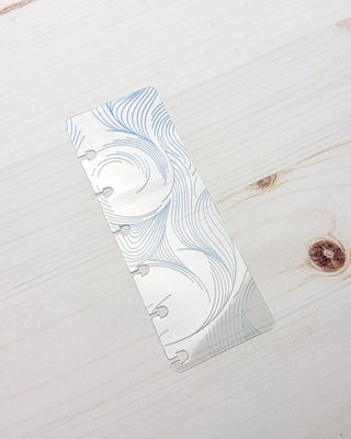 A clear plastic discbound planner page finder on a fake wooden background.   
