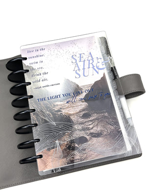 A planner featuring the Coastal Cove dashboard layered with the Sea, Air, & Sun Cover on a white background. 