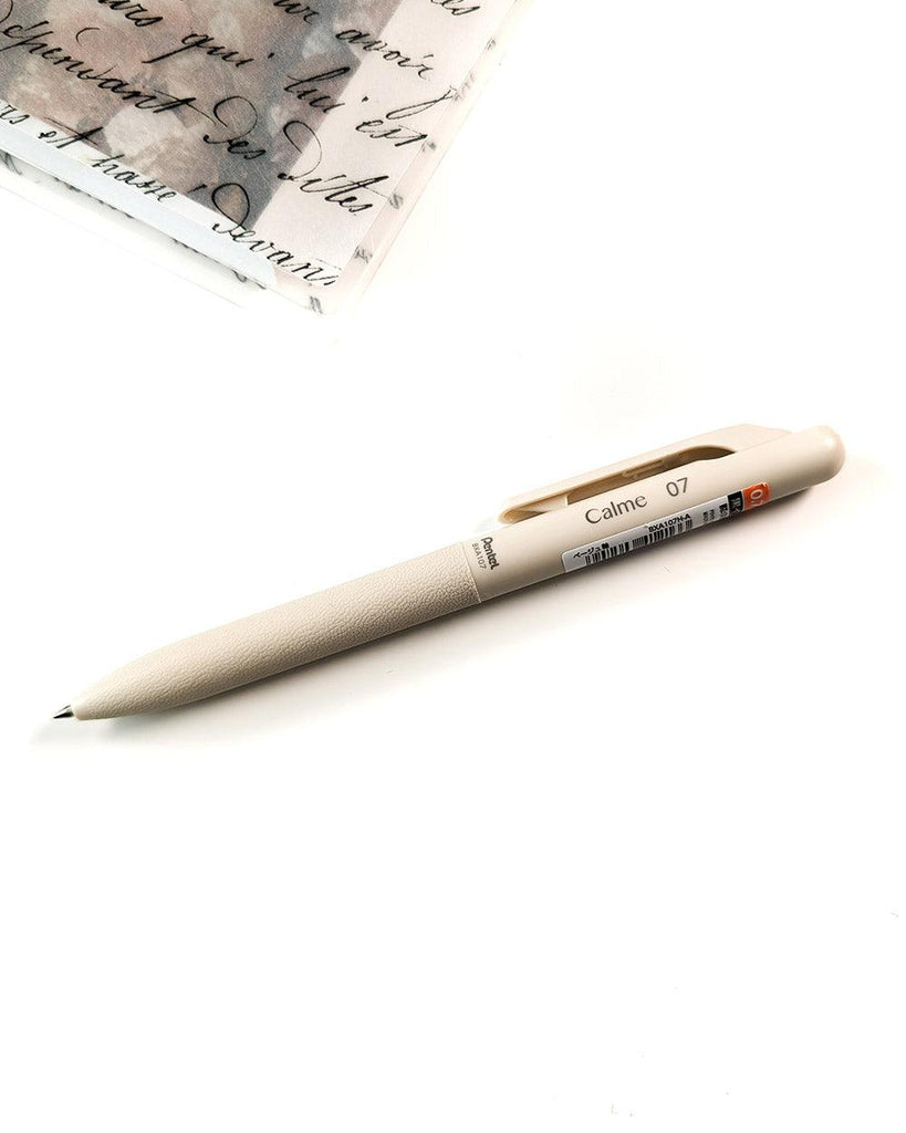 Pentel® oil based black ink pen with a creme plastic body and rubber grip.