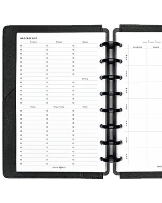 Black planner with open pages showing a grocery list and meal planning sections.