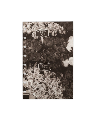 Sepia-toned photograph of flowers at a market with handwritten price signs, styled as a minimalist planner dashboard on a white background. 