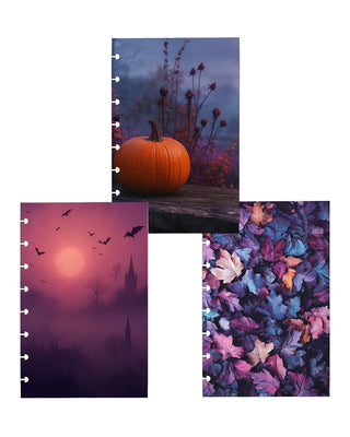 Three discbound planner dashboards featuring a moody autumn aesthetic: an orange pumpkin against a misty blue-purple landscape, a foggy pink and purple scene with bats and distant castle silhouettes, and a colorful arrangement of fallen leaves in shades of blue, purple, pink, and orange.