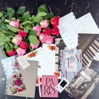 Bouquet of pink roses with stationery items on a dark surface