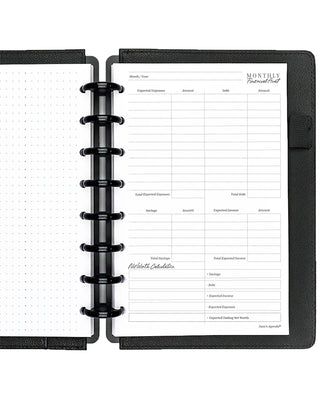 Open discbound planner with black cover and financial audit insert pages on a white background