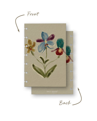 Front and back view of a removable discbound planner dashboard featuring a whimsical hand-painted floral illustration with oversized blue, purple, yellow, and teal blooms on a soft cream background. The coordinating back has a matching cream finish with subtle Jane’s Agenda branding.