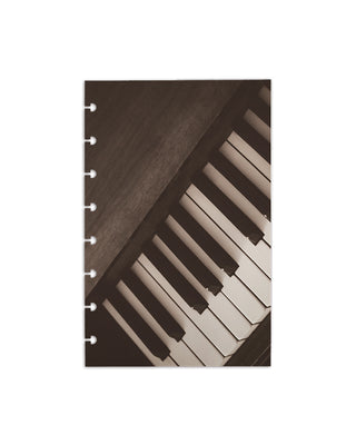 Close-up of piano keys in sepia tone printed on a heavy cardstock discbound planner dashboard, highlighting musical texture and vintage style on a white background. 