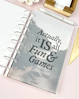 Discbound planner with a vellum paper dashboard featuring a gray typography  style quote sitting on a desk surface.