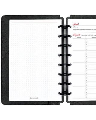 Open discbound planner with a page showing dot grid notes on a white background