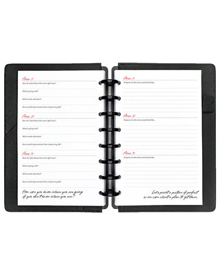 Black disc-bound planner with open pages on a white background