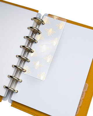 Gold foil bee pagefinder from Jane's Agenda placed inside yellow planner