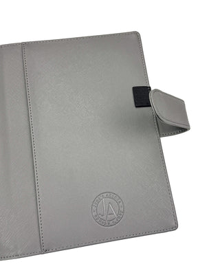 Grey Vegan Leather wrap cover featuring a closing strap, one pen loop and a back pocket for you planner to slide into. 