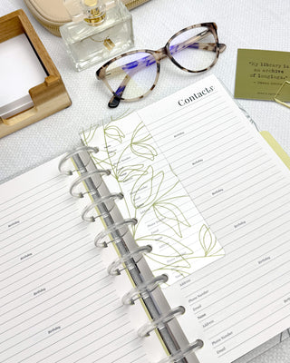 Discbound clear plastic page finder with embossed green plant outlines.