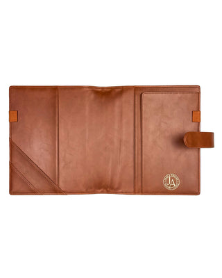 Fully opened warm brown leather planner cover displayed against a clean white background. The interior features two diagonal slip pockets, two full-length pockets, coordinating elastic pen loops on both sides, a matching leather snap closure, and a gold foil Jane’s Agenda logo, offering elegant organization with a timeless design.