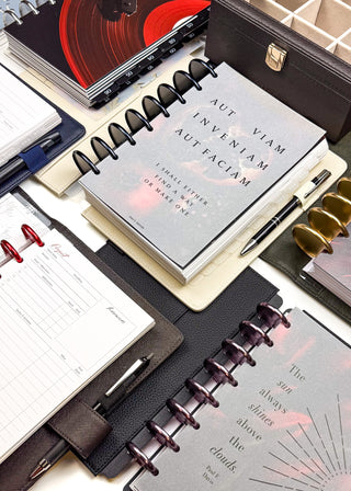 Collection of discbound planners and stationery items on a white surface