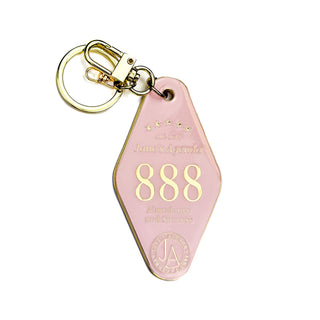 Pink keychain with gold accents and '888' numbers that represent success and abundance on a white background