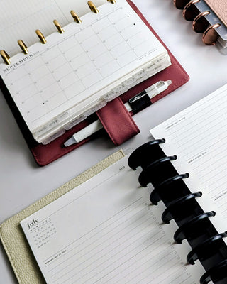 Planner Inserts inside discbound Planners on a white surface.