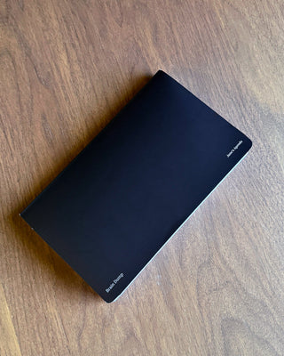 Black “Brain Dump” planner insert with a clean, minimalist design, featuring a full-page black writing surface with subtle Jane’s Agenda branding, photographed on a wooden tabletop.