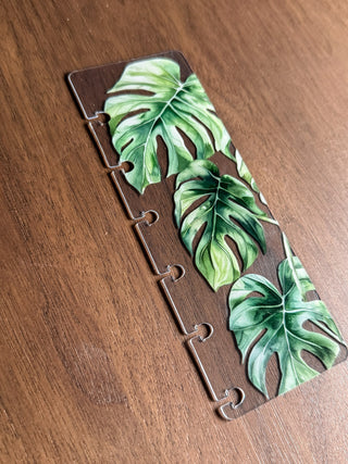 Jane's Agenda tropical monstera page finder for discbound planner systems — clear plastic with bold botanical print and disc-punch hook slots. A stylish planner organization essential.