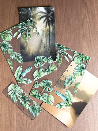 A clear discbound planner cover with a page finder, and decorative cardstock planner dashboards.