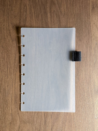 Jane's Agenda clear frosted Planner dashboard with elastic pen holder, disc-punched for discbound planner systems. A minimalist, durable plastic planner cover for Junior size Refillable Planner builds.