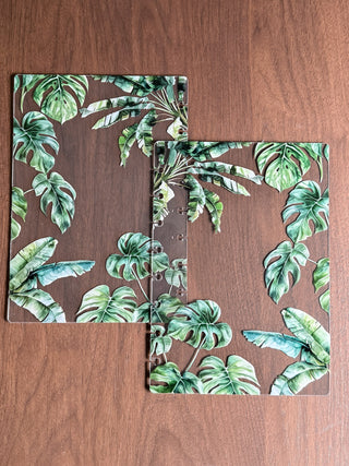 Jane's Agenda tropical botanical Planner Cover set — clear plastic front and back covers with monstera and banana leaf print, disc-punched for discbound planner systems. Bold nature-inspired planner covers.