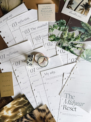 Planner pages with various topics and decorative planner accessories on a wooden surface.