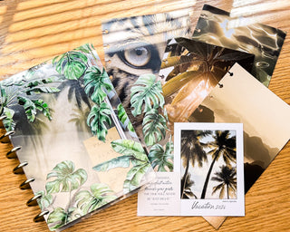 Collection of discbound planner stationery items with tropical designs on a wooden surface