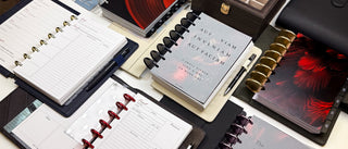 Collection of discbound planners and stationery items on a white surface
