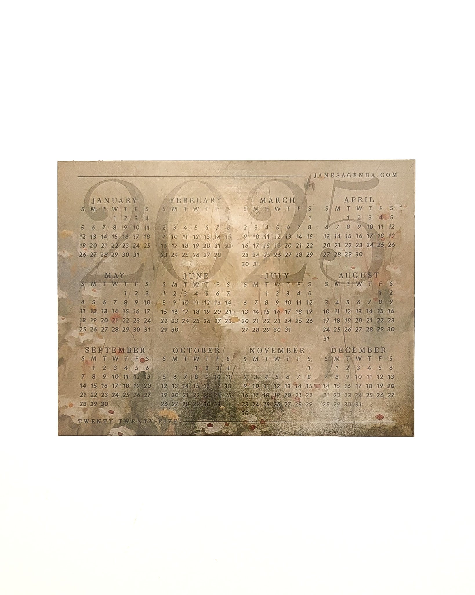 Gold-toned 2025 calendar magnet with a floral background displayed flat against a white surface.