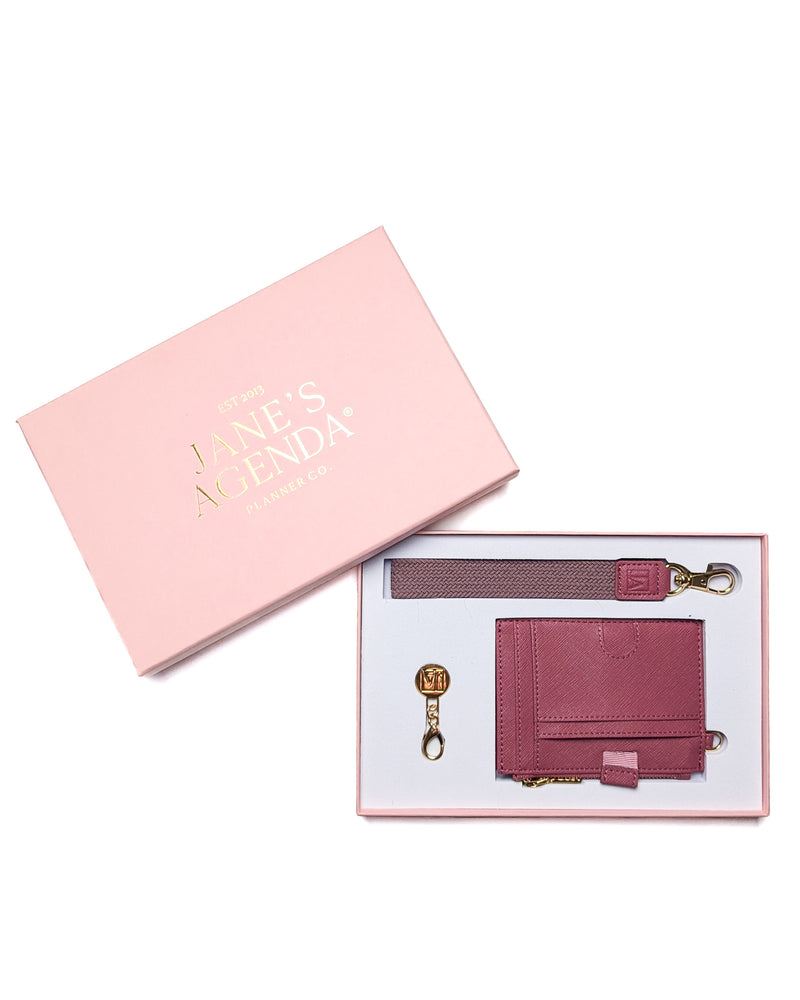Rouge pink wallet, wrist strap, and gold charm in a pink Jane's Agenda gift box