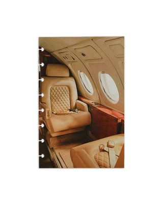A planner dashboard with an image of a luxury airplane cabin interior with beige leather seats and overhead compartments.