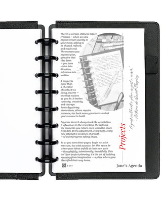 Project planner inserts inside a black discbound planner notebook over a white background.