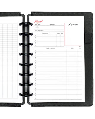 Project planner inserts inside a black discbound planner notebook over a white background.