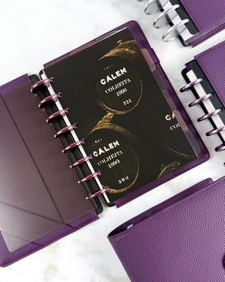 Purple discbound planner with purple vegan leather planner cover and a decoative cardstock planner dashboard of dark wine barrels.