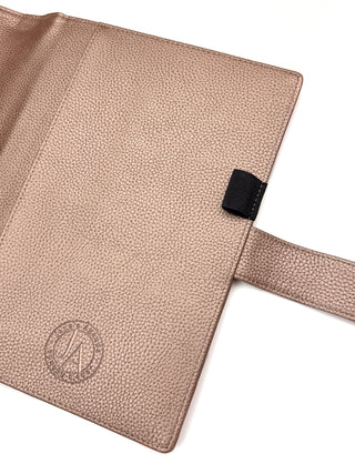Rose gold vegan leather planner cover for discbound panners over a white background.