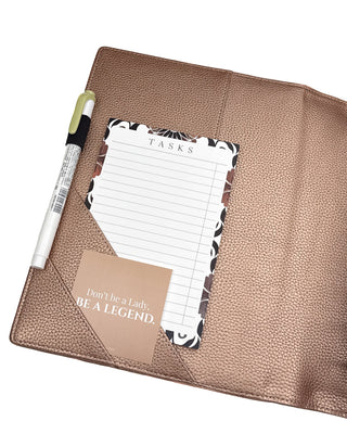 Rose gold vegan leather planner cover for discbound panners over a white background.