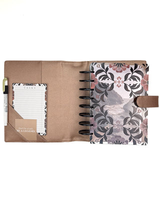 Rose gold vegan leather planner cover for discbound panners over a white background.