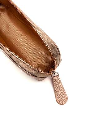 Close-up of a gold penpouch with a zipper on a white background