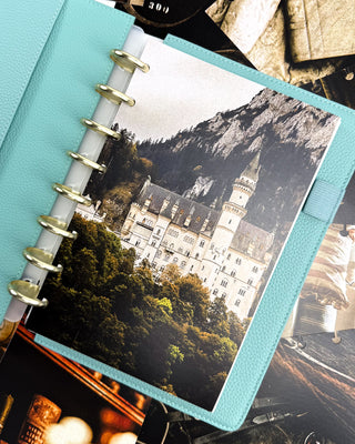 Discbound planner with Champagne metal discs and a decorative cardstock dashboard or a white castle on the side of a mountain.