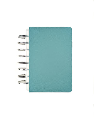 Light teal planner with silver metal binding discs on a white background