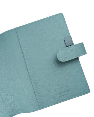Light blue planner cover with strap on a white background